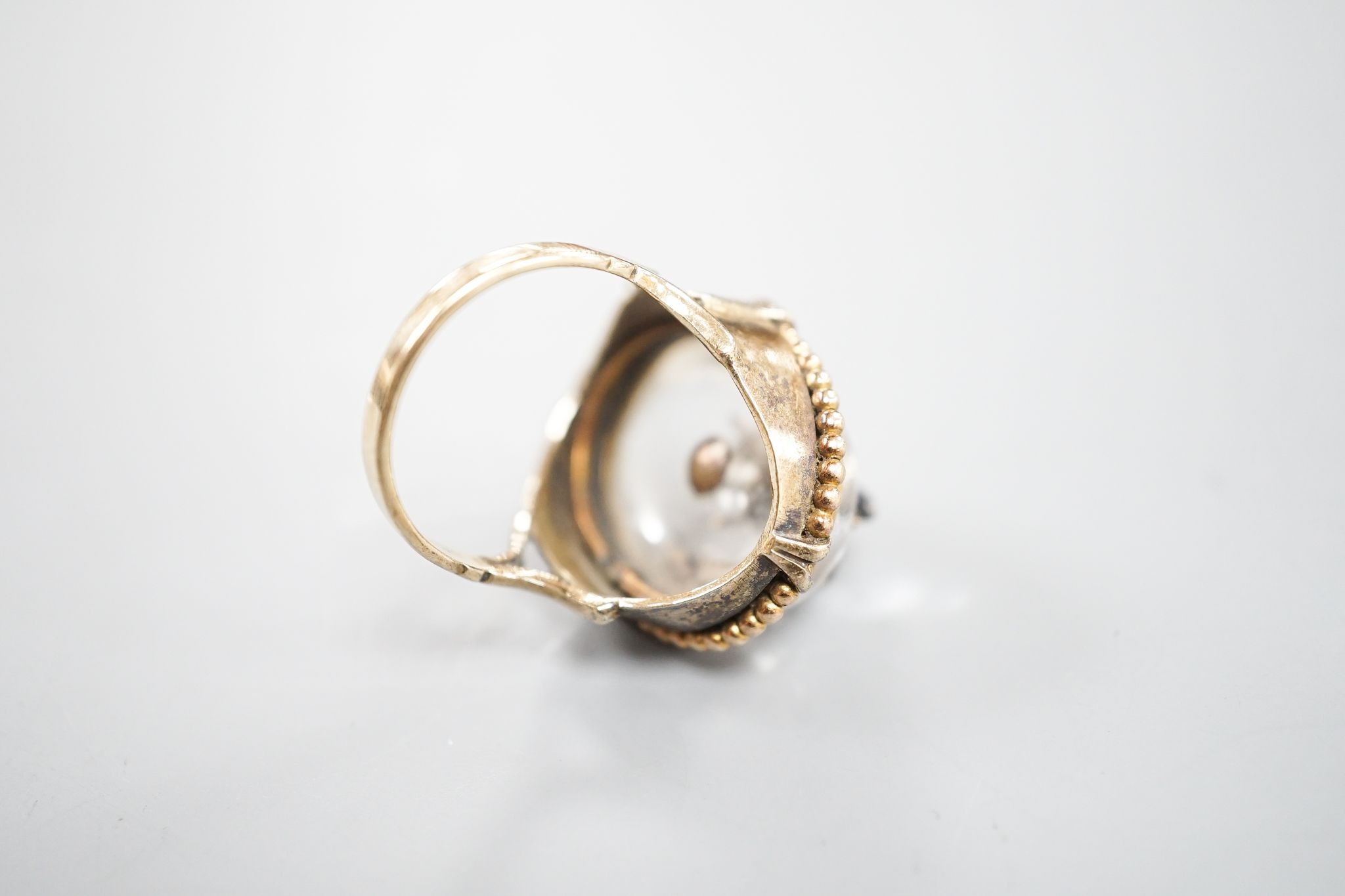 A Victorian, yellow metal and cabochon rock crystal? set dress ring, with central gem set bug motif, size R/S, gross weight 12.4 grams.